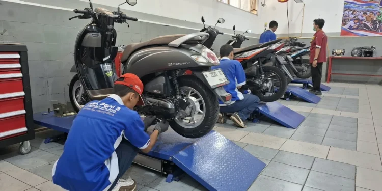 Siswa SMK PGRI 3 Malang mendapat pengalaman kerja nyata lewat program servis motor gratis dalam rangka HUT Jatim ke-81. Foto: Azmy